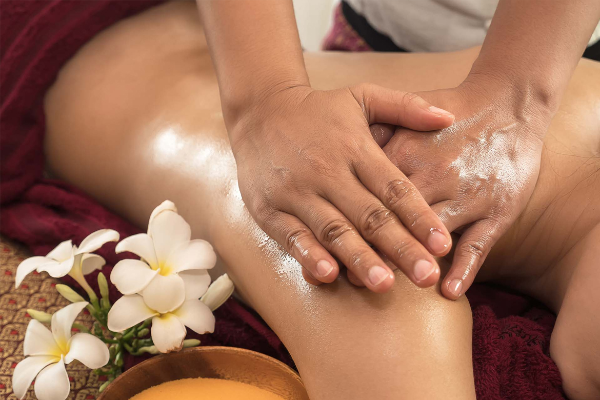 A skilled massage specialist at Glamour Spa Islamabad expertly applies aromatic oils while performing a therapeutic shoulder massage, promoting relaxation and relieving tension in a serene spa environment.
